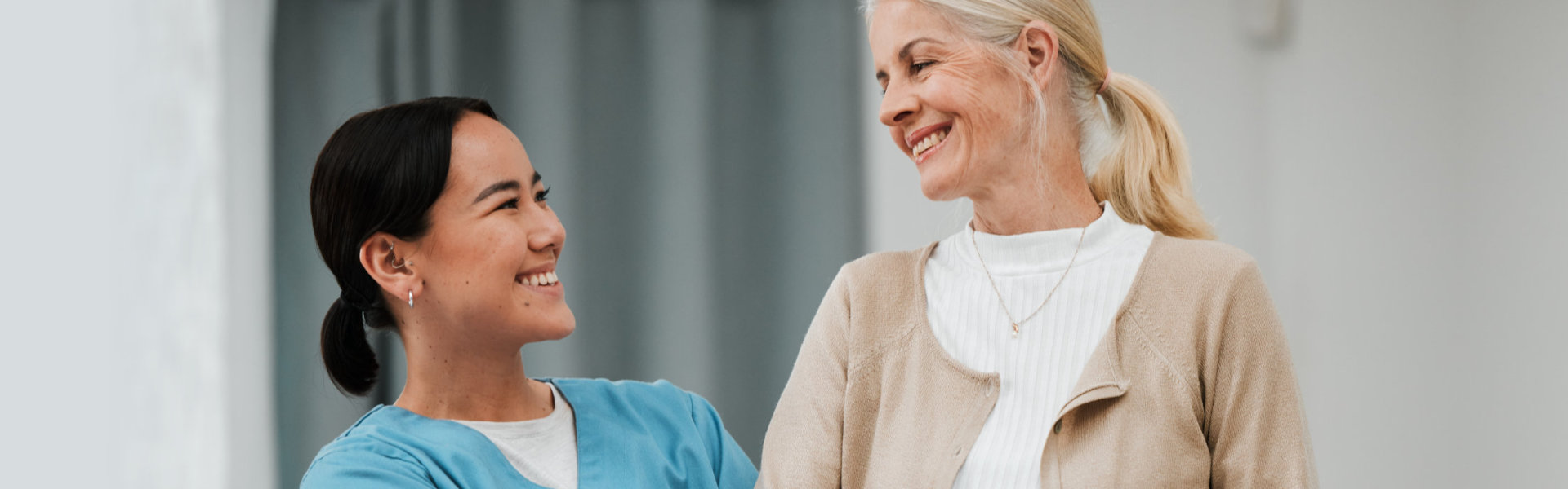 caregiver and senior looking to each other and smiling